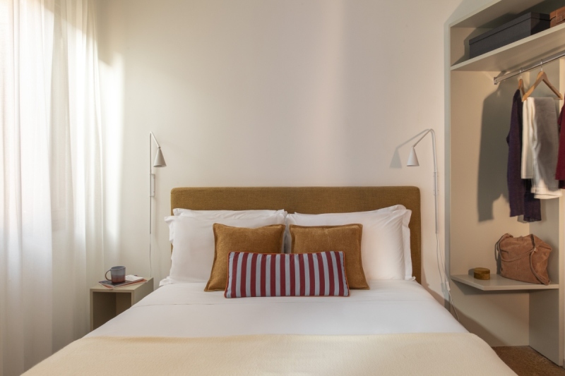 Detail of modern double bed in Standard room with textured ochre pillows and modern wall lamps - Ca' La Stampa, BZAR hotels in Venice