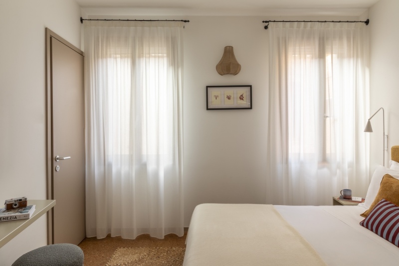 Bright Standard room interior in Venice with two large windows, sheer curtains, and typical Venetian flooring - Ca' La Stampa, BZAR hotels in Venice