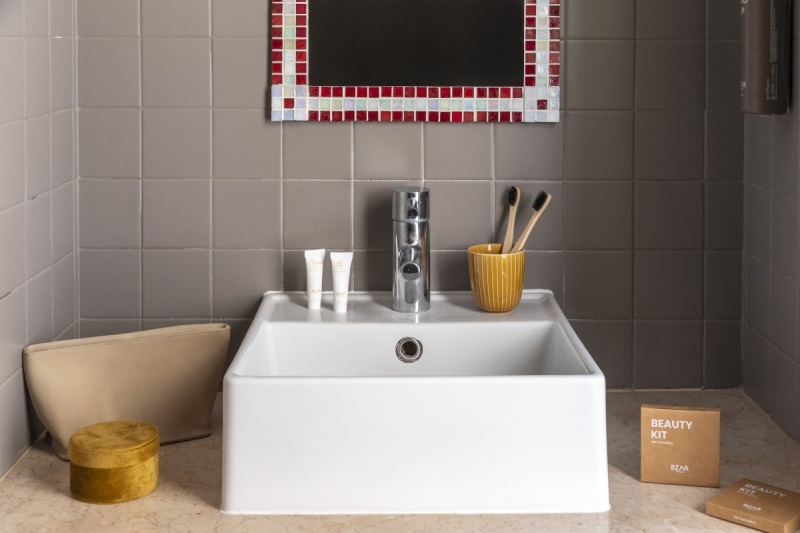 Detail of Standard room bathroom sink with mosaic mirror, branded amenity kits, and toothbrush holder - Ca' La Stampa, BZAR hotels in Venice